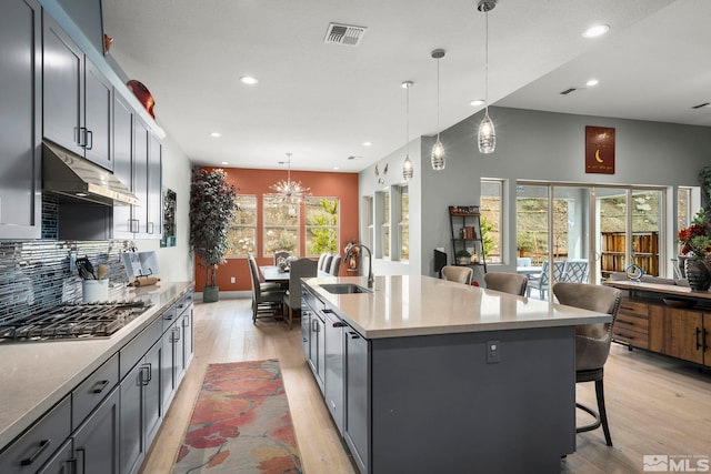 9179 Graycliff Ln, Reno, NV 89523 - kitchen with a sink, stainless steel gas stovetop, under cabinet range hood, recessed lighting, and light wood-type flooring