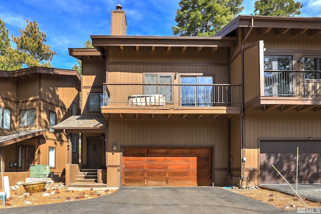 8 Katherine Ct, Stateline, NV 89449 - view of front of property with a balcony, an attached garage, a chimney, and driveway
