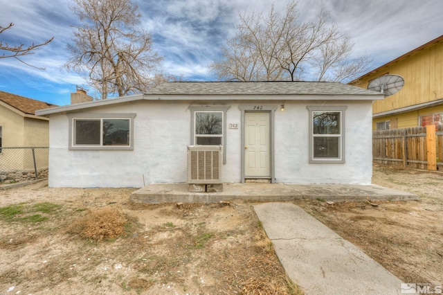 742 D St, Hawthorne, NV 89415 - view of front of home with fence, stucco siding, roof with shingles, and a chimney