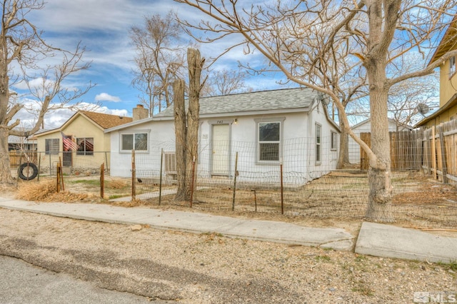 742 D St, Hawthorne, NV 89415 - view of front of house featuring a shingled roof, a chimney, a fenced front yard, and stucco siding