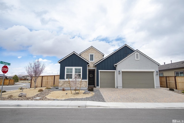 view of front facade featuring board and batten siding, a garage, fence, and driveway