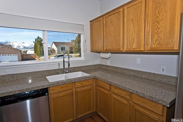3953 Boundary Peak Ct, Reno, NV 89508 - kitchen with stainless steel dishwasher, a sink, dark stone counters, and brown cabinetry