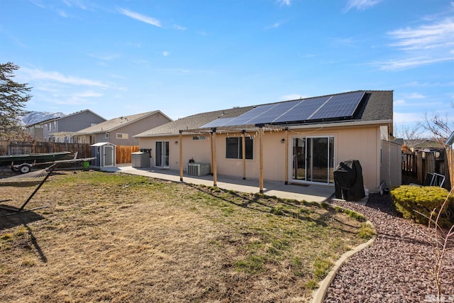 9834 Suncrest Dr, Reno, NV 89506 - rear view of house featuring a storage shed, a patio area, roof mounted solar panels, an outbuilding, and central air condition unit