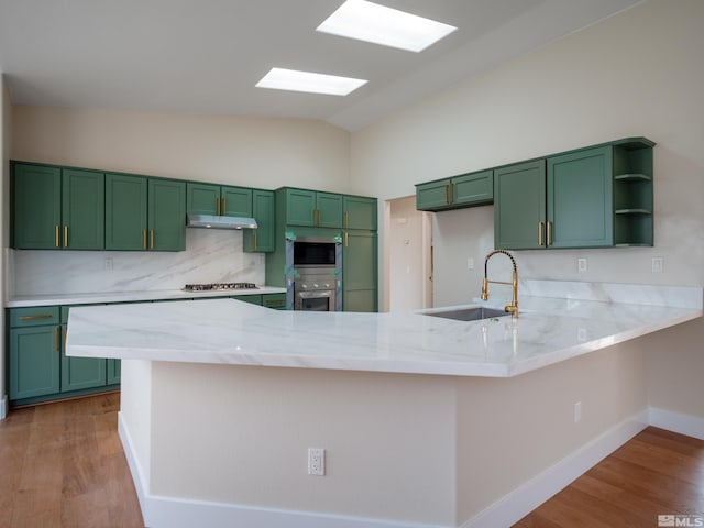 1771 Lantana Dr, Minden, NV 89423 - kitchen with a sink, green cabinetry, vaulted ceiling, and a peninsula