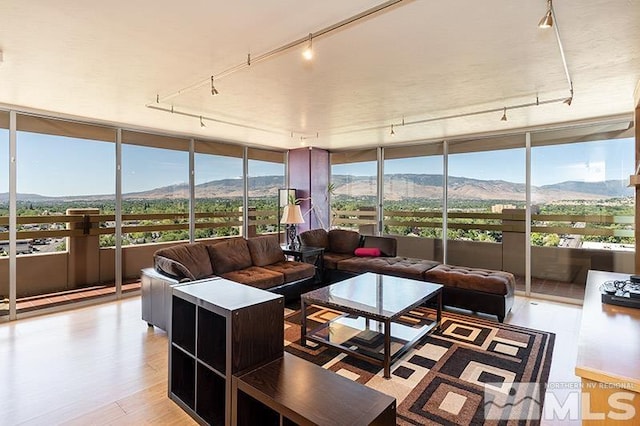 100 N Arlington Ave Unit 14F, Reno, NV 89501 - sunroom / solarium with rail lighting, a mountain view, a wall of windows, and wood finished floors