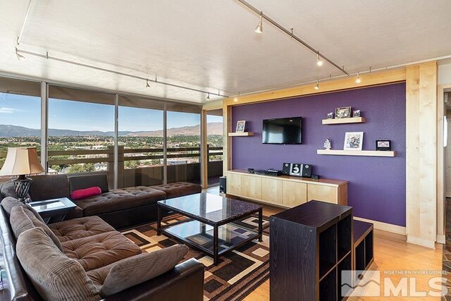 100 N Arlington Ave Unit 14F, Reno, NV 89501 - living room featuring rail lighting, a wall of windows, light wood-type flooring, and baseboards