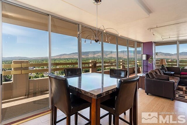 100 N Arlington Ave Unit 14F, Reno, NV 89501 - sunroom / solarium featuring a mountain view, a wall of windows, tile patterned floors, track lighting, and a chandelier