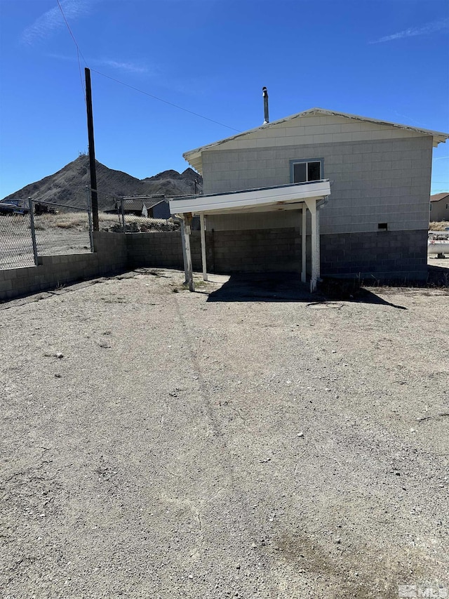 481 S Frankie St, Tonopah, NV 89049 - view of side of property featuring fence, concrete block siding, and a mountain view