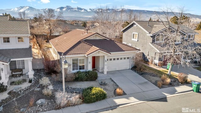 10055 Zephyr Heights Dr, Reno, NV 89521 - traditional-style house with stucco siding, a garage, a tile roof, driveway, and a mountain view