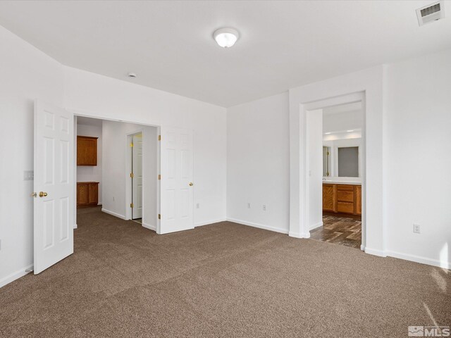 915 Lakeview Dr, Dayton, NV 89403 - unfurnished bedroom with dark colored carpet, baseboards, and connected bathroom