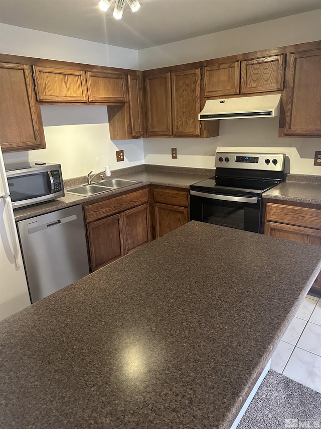 1465 E Peckham Ln Apt 40, Reno, NV 89502 - kitchen featuring stainless steel appliances, exhaust hood, dark countertops, a sink, and brown cabinets