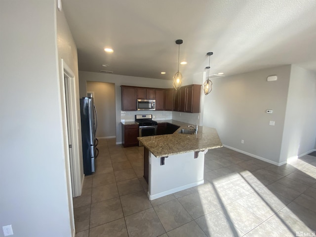 756 Iron Stirrup Ct, Sparks, NV 89436 - kitchen with stainless steel appliances, a sink, light tile patterned floors, a peninsula, and a breakfast bar