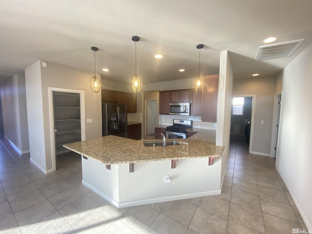 756 Iron Stirrup Ct, Sparks, NV 89436 - kitchen featuring stainless steel appliances, a peninsula, a sink, light tile patterned floors, and a kitchen breakfast bar