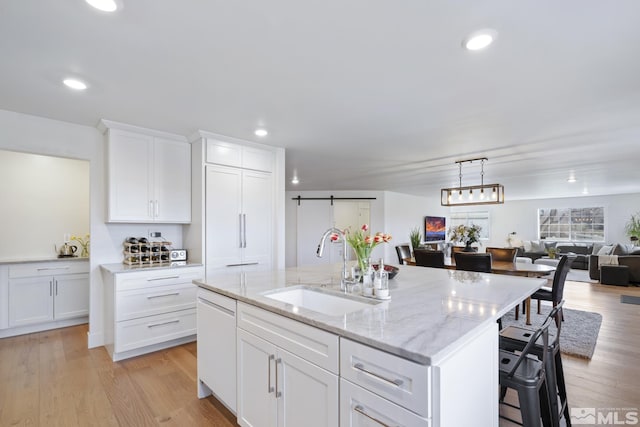 915 Maple Creek Ct, Reno, NV 89511 - kitchen with a sink, a kitchen island with sink, recessed lighting, white cabinetry, and light wood-style flooring
