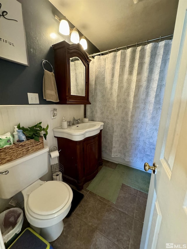 96 E Eisenhower Ave, Winnemucca, NV 89445 - bathroom with toilet, vanity, a wainscoted wall, a shower with curtain, and tile patterned flooring