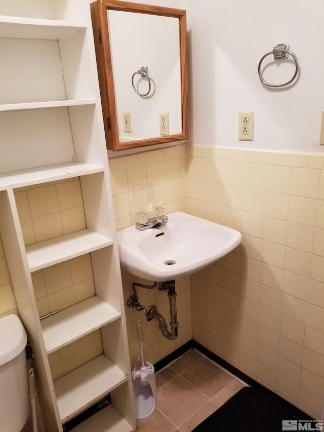 96 E Eisenhower Ave, Winnemucca, NV 89445 - half bathroom with tile walls, a sink, wainscoting, toilet, and tile patterned floors