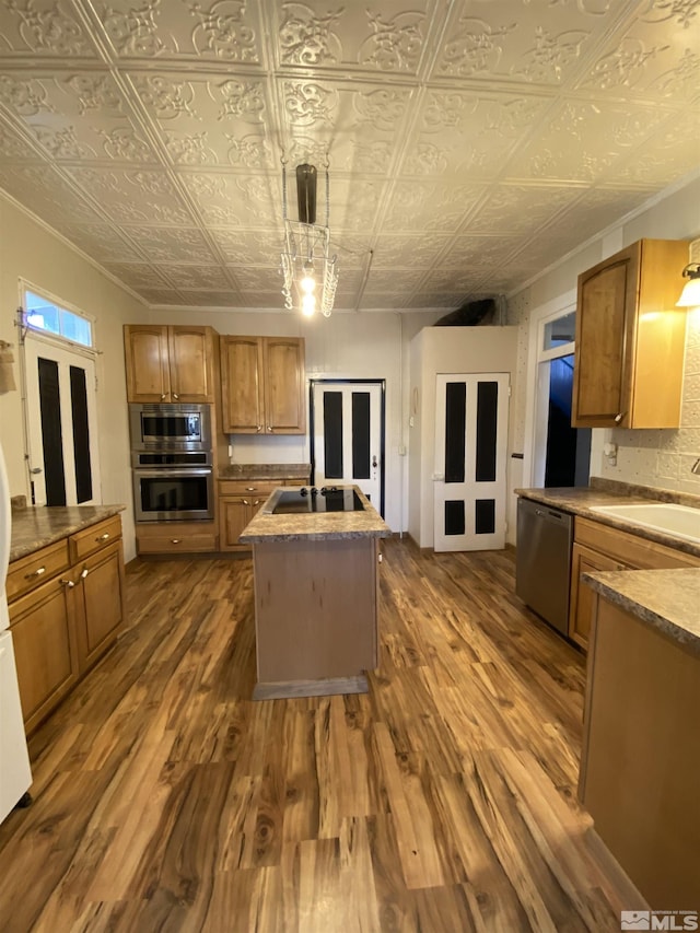 85 S Main, Paradise Valley, NV 89426 - kitchen with appliances with stainless steel finishes, a sink, an ornate ceiling, brown cabinetry, and dark wood finished floors