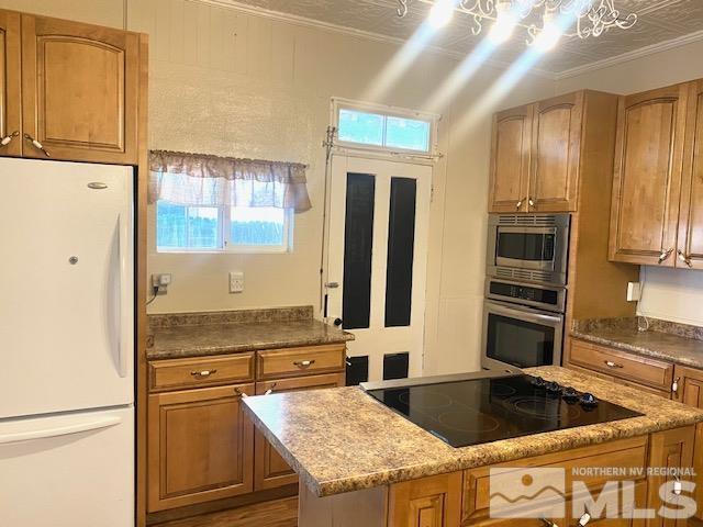 85 S Main, Paradise Valley, NV 89426 - kitchen featuring appliances with stainless steel finishes, brown cabinetry, and a center island