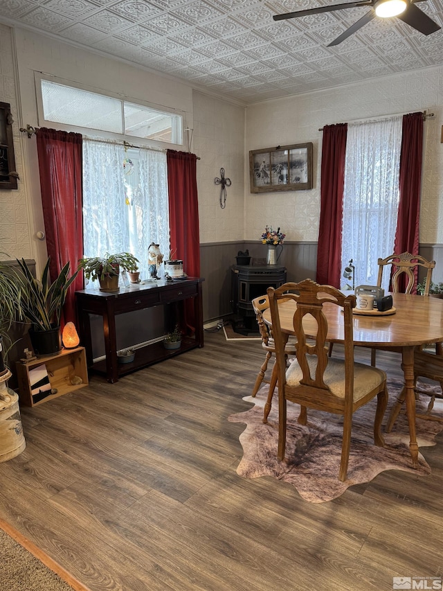 85 S Main, Paradise Valley, NV 89426 - dining area featuring a wood stove, an ornate ceiling, a ceiling fan, wood finished floors, and healthy amount of natural light