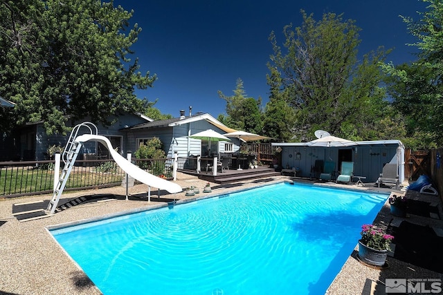 1360 Dartmouth Dr, Reno, NV 89509 - view of pool featuring a water slide, fence, a deck, and an outdoor structure