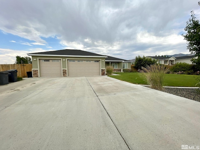 ranch-style home featuring concrete driveway, stone siding, and a garage