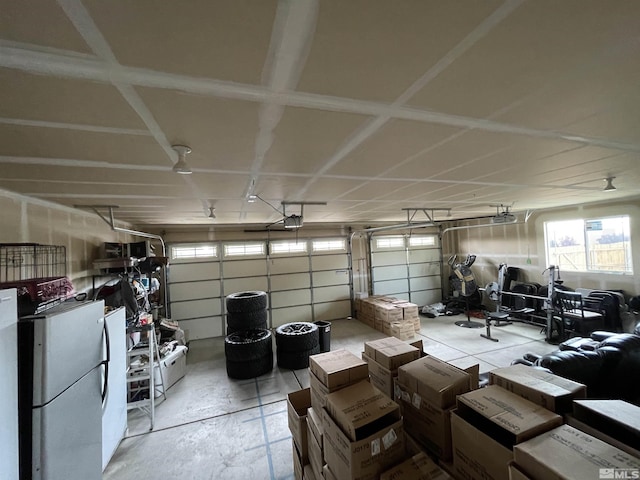 garage featuring freestanding refrigerator and a garage door opener
