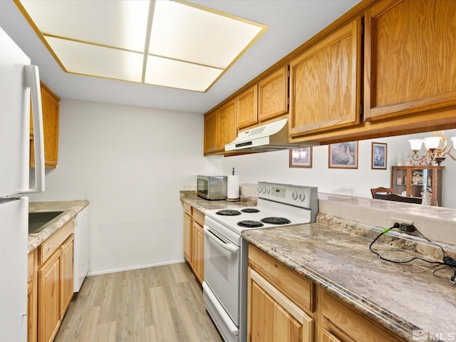 2845 Idlewild Dr # 210, Reno, NV 89509 - kitchen featuring white appliances, under cabinet range hood, light wood-type flooring, baseboards, and light stone countertops