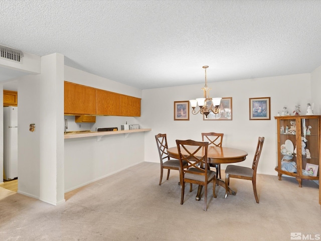 2845 Idlewild Dr # 210, Reno, NV 89509 - dining area featuring light carpet, a chandelier, and a textured ceiling