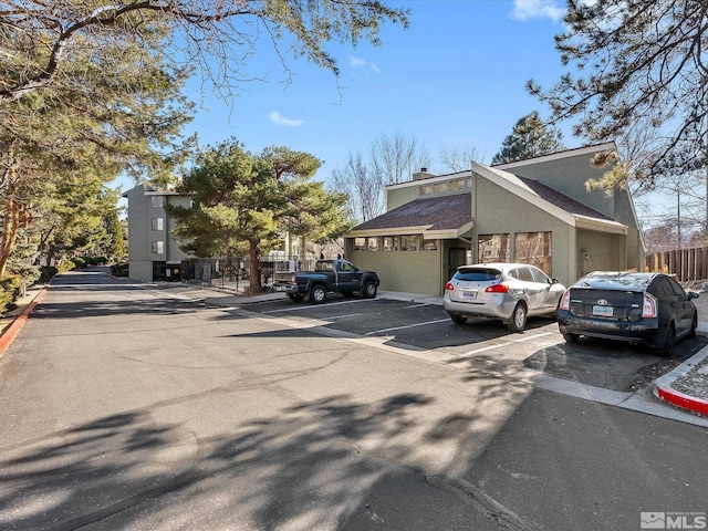 2845 Idlewild Dr # 210, Reno, NV 89509 - view of front of home featuring uncovered parking, stucco siding, and fence
