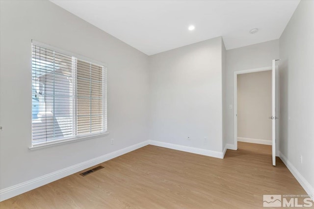 empty room featuring light wood-style flooring and baseboards