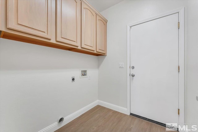 clothes washing area with cabinet space, washer hookup, light wood-style floors, hookup for an electric dryer, and baseboards