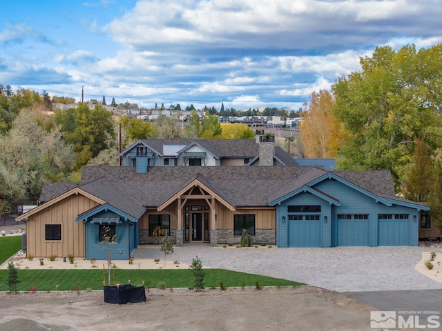 4090 Goodsell Ln, Reno, NV 89523 - view of front of home featuring board and batten siding, an attached garage, stone siding, and decorative driveway