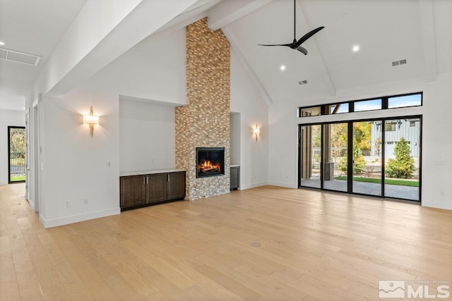 4090 Goodsell Ln, Reno, NV 89523 - unfurnished living room with a towering ceiling, a ceiling fan, light wood-style floors, a tile fireplace, and beam ceiling