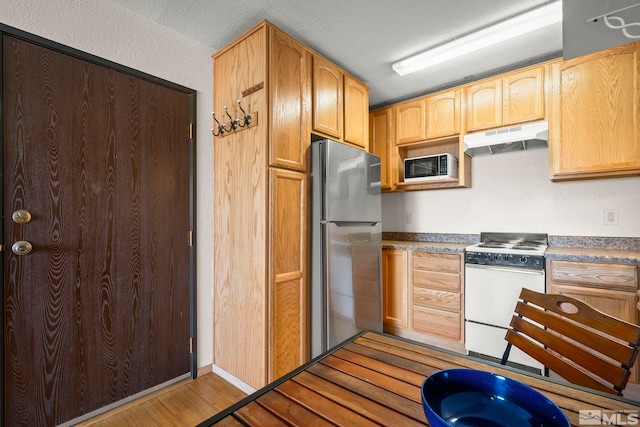2450 Lymbery St Unit 206, Reno, NV 89509 - kitchen featuring white range with gas cooktop, freestanding refrigerator, under cabinet range hood, light wood finished floors, and a textured ceiling