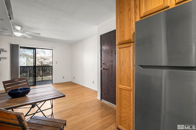 2450 Lymbery St Unit 206, Reno, NV 89509 - kitchen with freestanding refrigerator, ceiling fan, light wood finished floors, and brown cabinetry