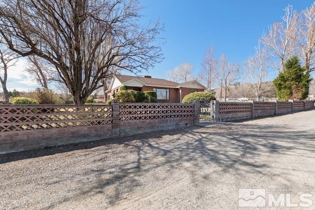 view of front of home with a fenced front yard and a gate