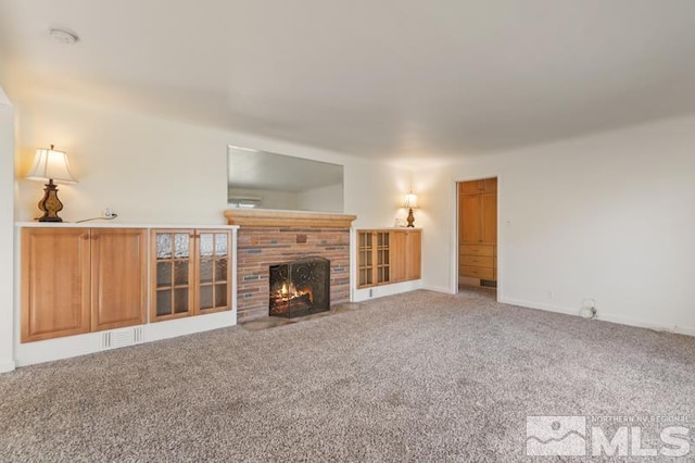 unfurnished living room featuring light carpet, a fireplace, and baseboards