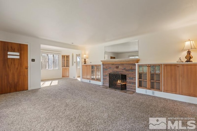 unfurnished living room with a brick fireplace and carpet flooring