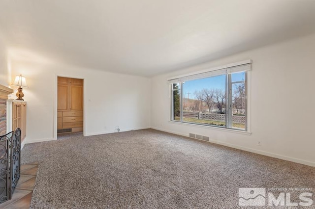 unfurnished living room featuring carpet floors and baseboards