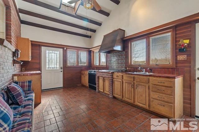 kitchen with tile countertops, custom exhaust hood, a sink, ceiling fan, and beam ceiling