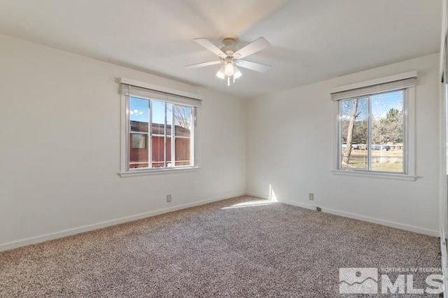 carpeted empty room with a ceiling fan and baseboards