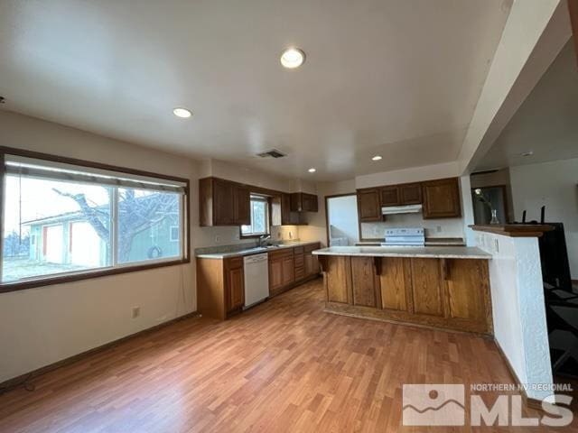 1036 Arrowhead Dr, Gardnerville, NV 89460 - kitchen with white appliances, under cabinet range hood, light countertops, light wood finished floors, and recessed lighting