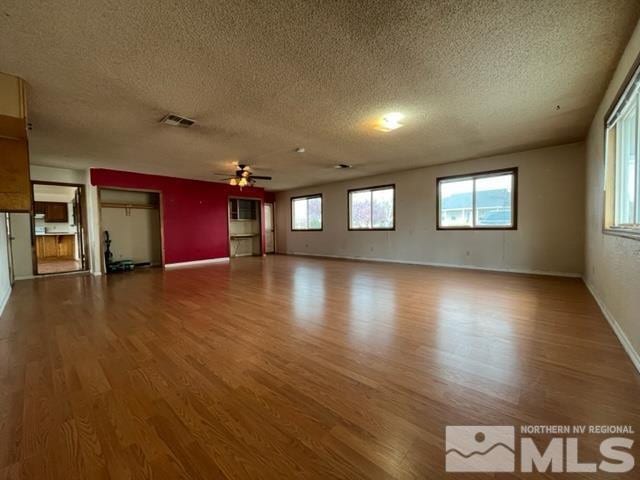 1036 Arrowhead Dr, Gardnerville, NV 89460 - unfurnished living room featuring wood finished floors, a textured ceiling, and ceiling fan