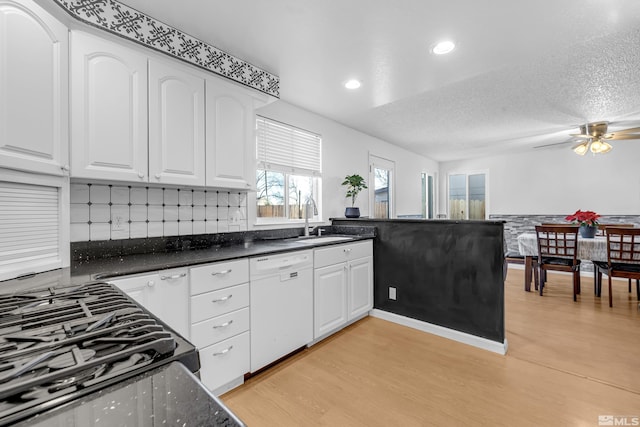 6357 Moon Ridge Ter, Reno, NV 89523 - kitchen with white dishwasher, a sink, light wood-style flooring, white cabinetry, and gas range