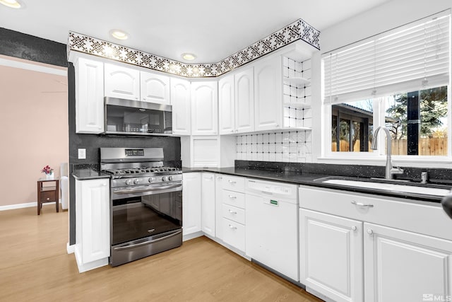 6357 Moon Ridge Ter, Reno, NV 89523 - kitchen featuring stainless steel appliances, white cabinetry, dark countertops, light wood-type flooring, and decorative backsplash