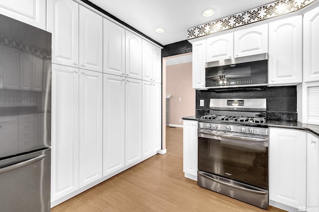 6357 Moon Ridge Ter, Reno, NV 89523 - kitchen with appliances with stainless steel finishes, dark countertops, white cabinetry, light wood-style flooring, and recessed lighting