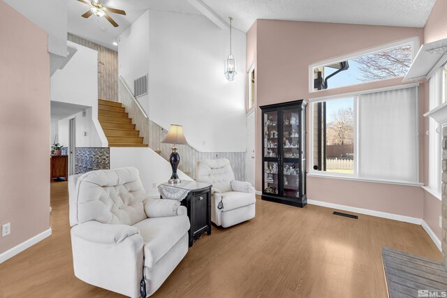 6357 Moon Ridge Ter, Reno, NV 89523 - living area featuring high vaulted ceiling, ceiling fan, wood finished floors, baseboards, and stairway