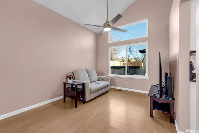 6357 Moon Ridge Ter, Reno, NV 89523 - living area featuring high vaulted ceiling, ceiling fan, light wood-style floors, and baseboards