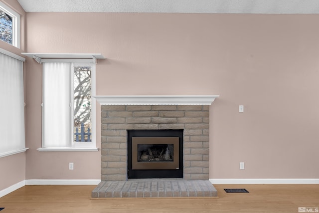6357 Moon Ridge Ter, Reno, NV 89523 - detailed view of wood finished floors, a brick fireplace, and baseboards