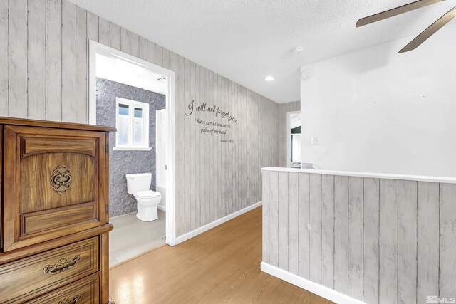 6357 Moon Ridge Ter, Reno, NV 89523 - hallway featuring light wood-type flooring, a textured ceiling, and baseboards